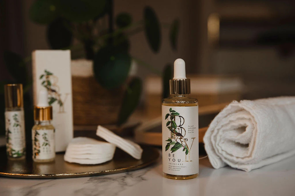 Ultra-nährendes Körper-, Haut- und Haaröl 4 Hautpflegeöl mit natürlichen Inhaltsstoffen auf einem Badezimmer-Tisch, Wellness, Spa.