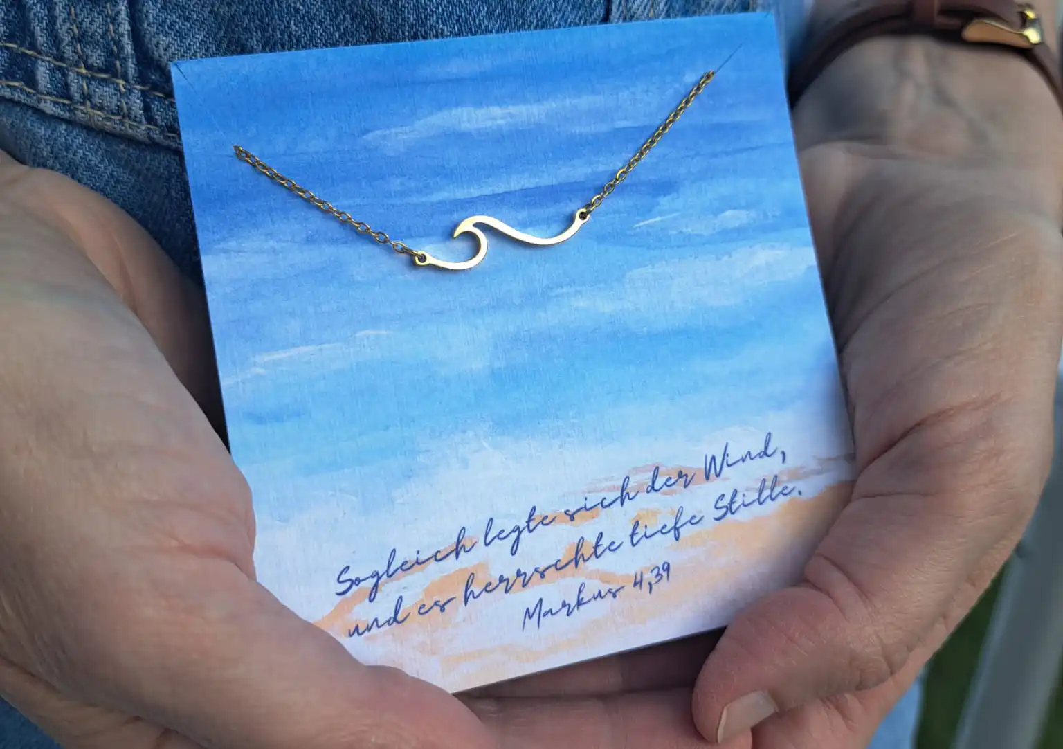 Der Himmel mit Wolken und Bibelvers auf Karte, silberne Halskette mit Wellenanhänger, christliches S.