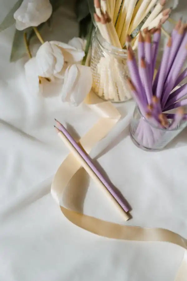 Gebetspensilien und christliche Symbole auf einem weißen Tuch, spirituelle Atmosphäre.