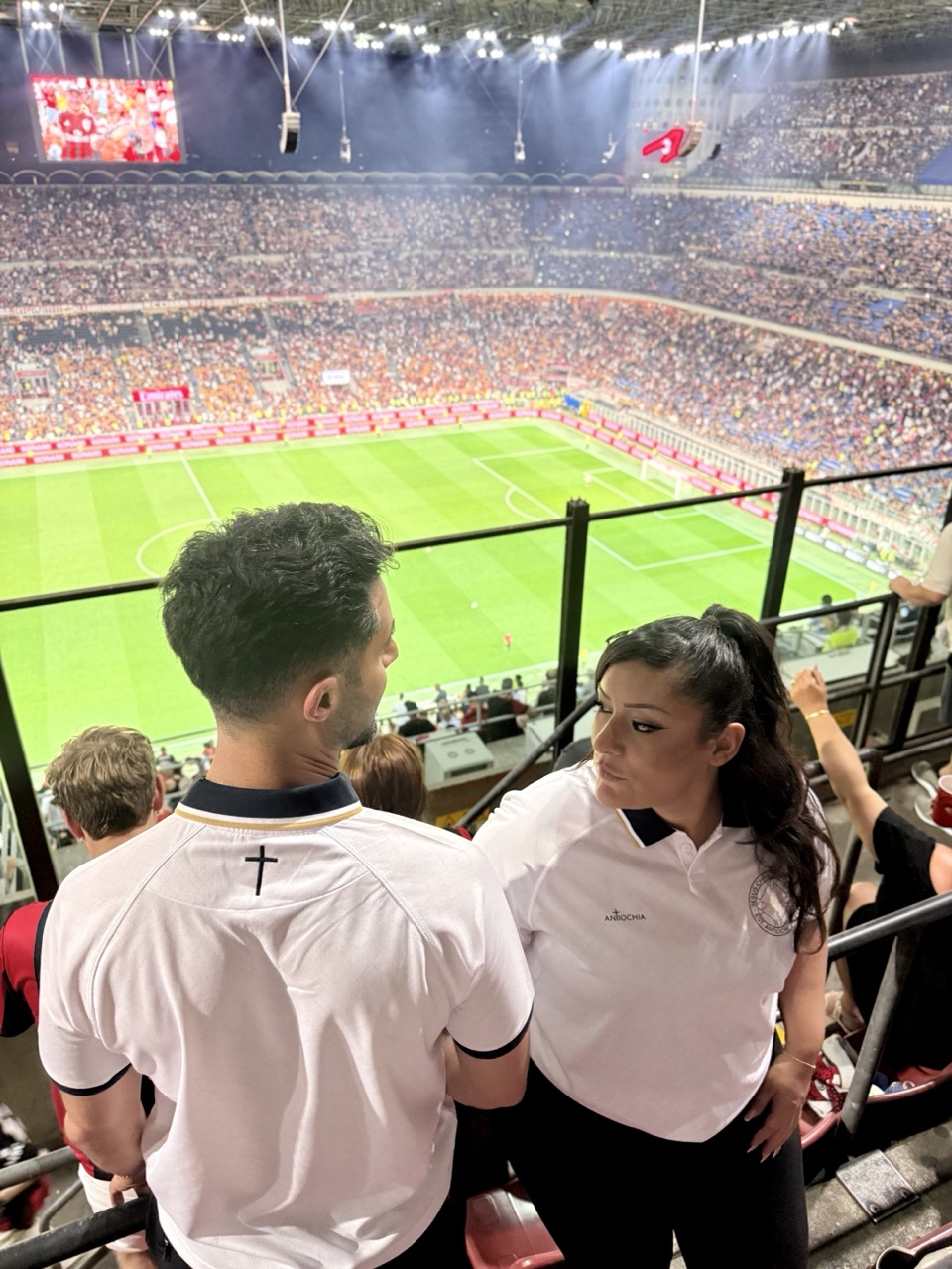 Sieger-Trikot - "Jesus Christ conquers" 2 Fußballstadion mit Zuschauern, Blick auf das Spielfeld und Fans im Stadion.