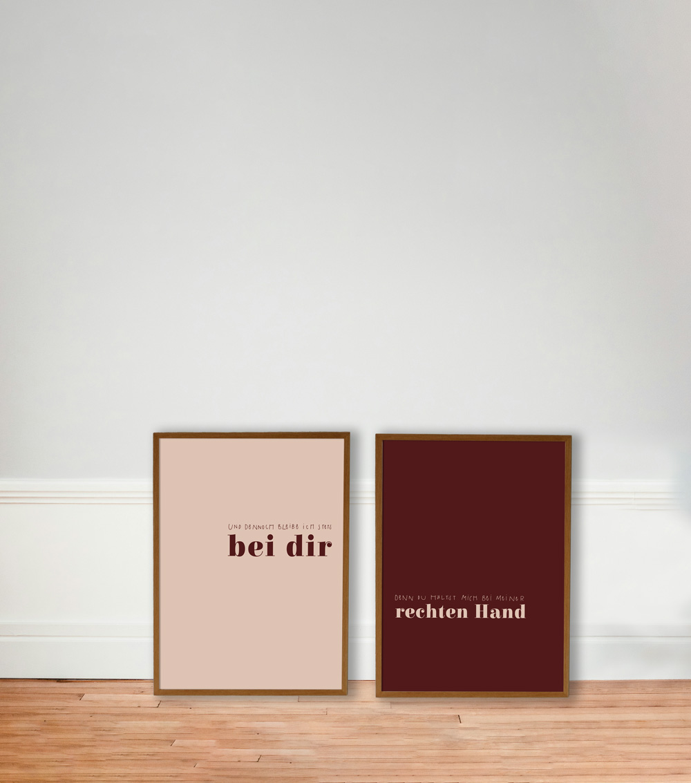 POSTER-DUO "UND DENNOCH" 1 Ein christliches Zitat in zwei Bilderrahmen, auf Holzboden vor weißer Wand.
