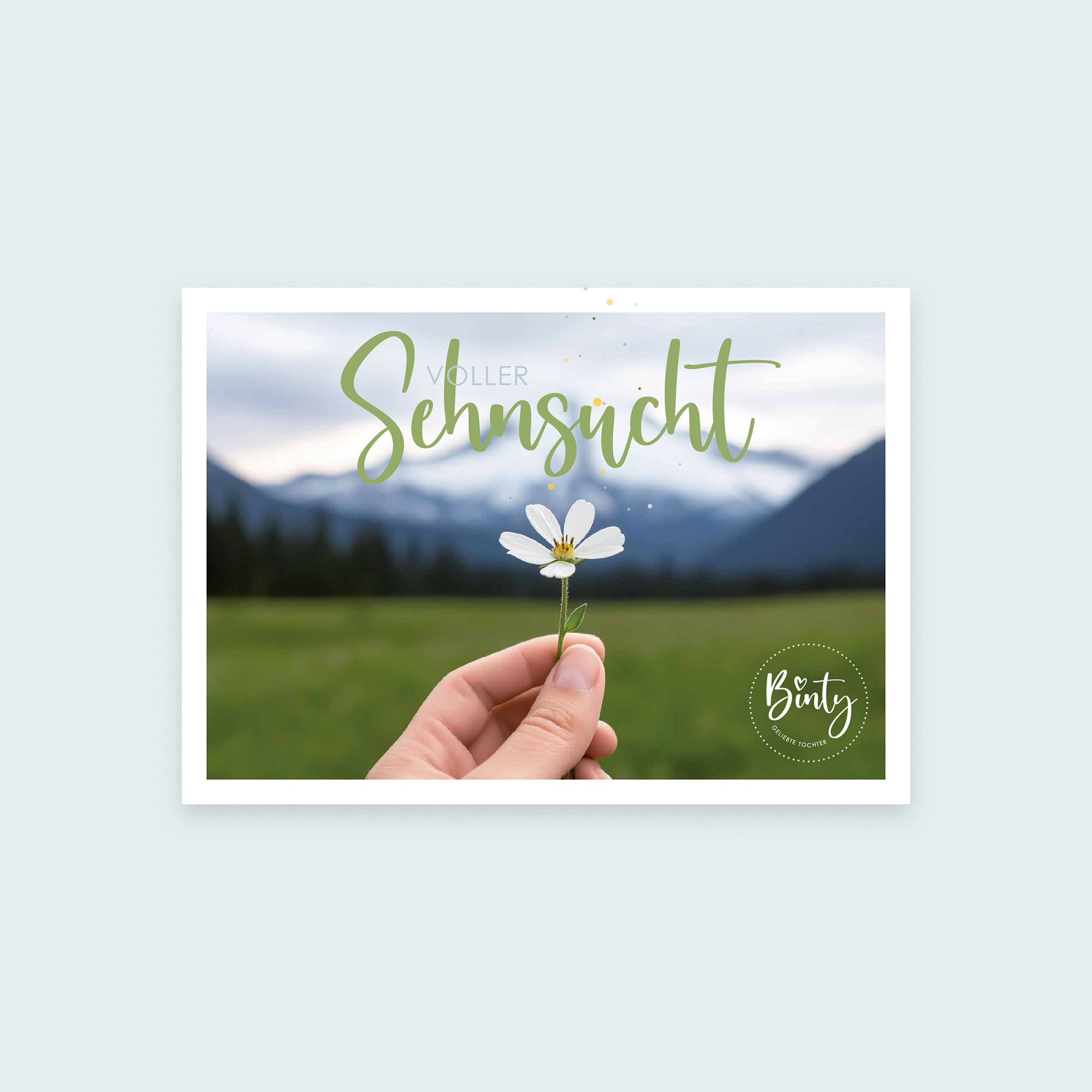 Postkarten Bundle | Frühlingsedition Bärbel 2 Hand hält Gänseblümchen vor Berglandschaft mit Himmel und Wolken.