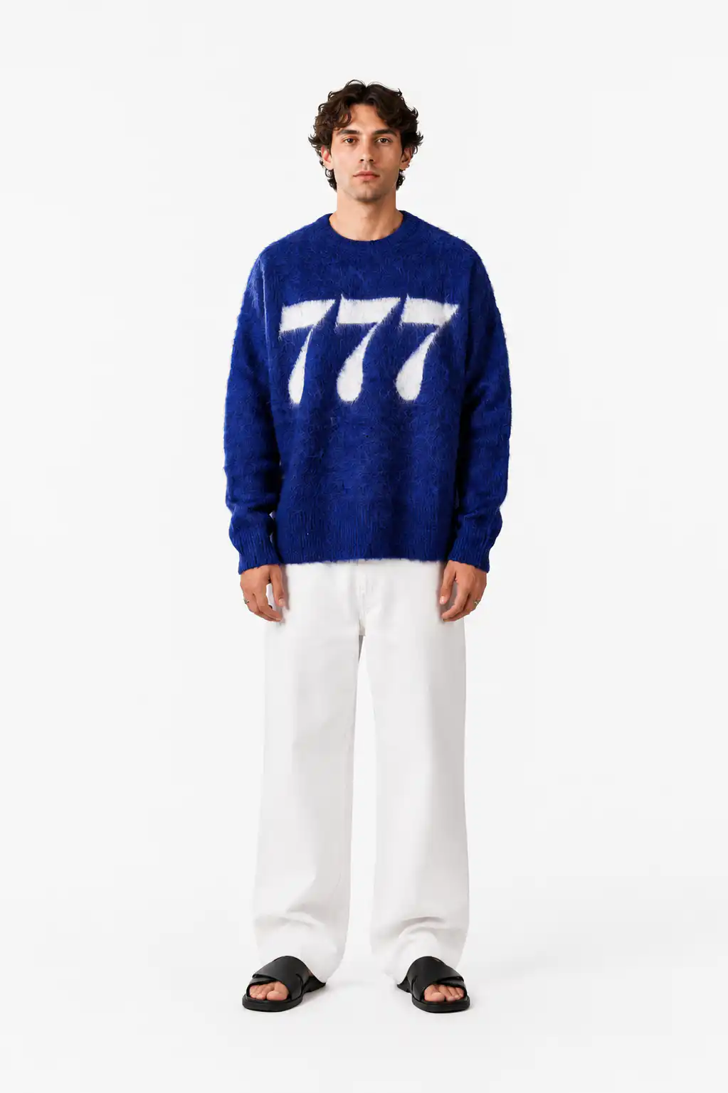 Der junge Mann trägt einen blauen Pullover mit weißen Sieben, christliches Modeaccessoire.