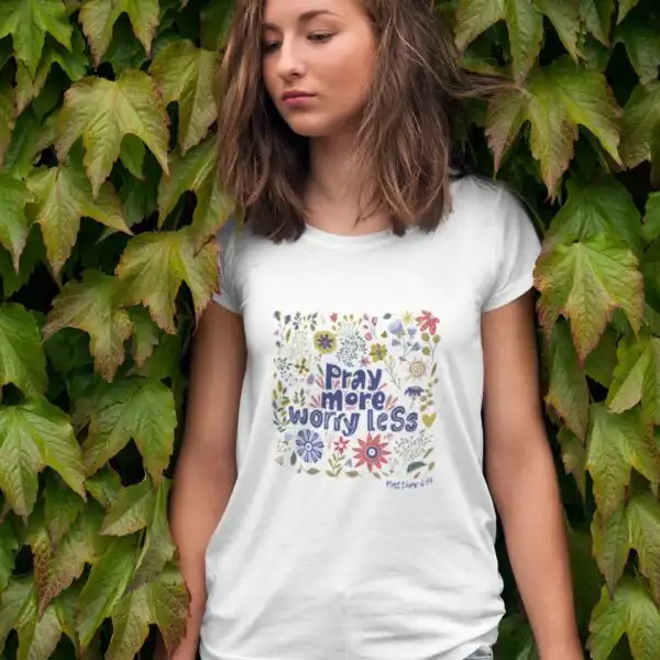 Bildausschnitt einer jungen Frau mit T-Shirt mit dem Aufdruck "Pray more worry less" vor einer grüne.