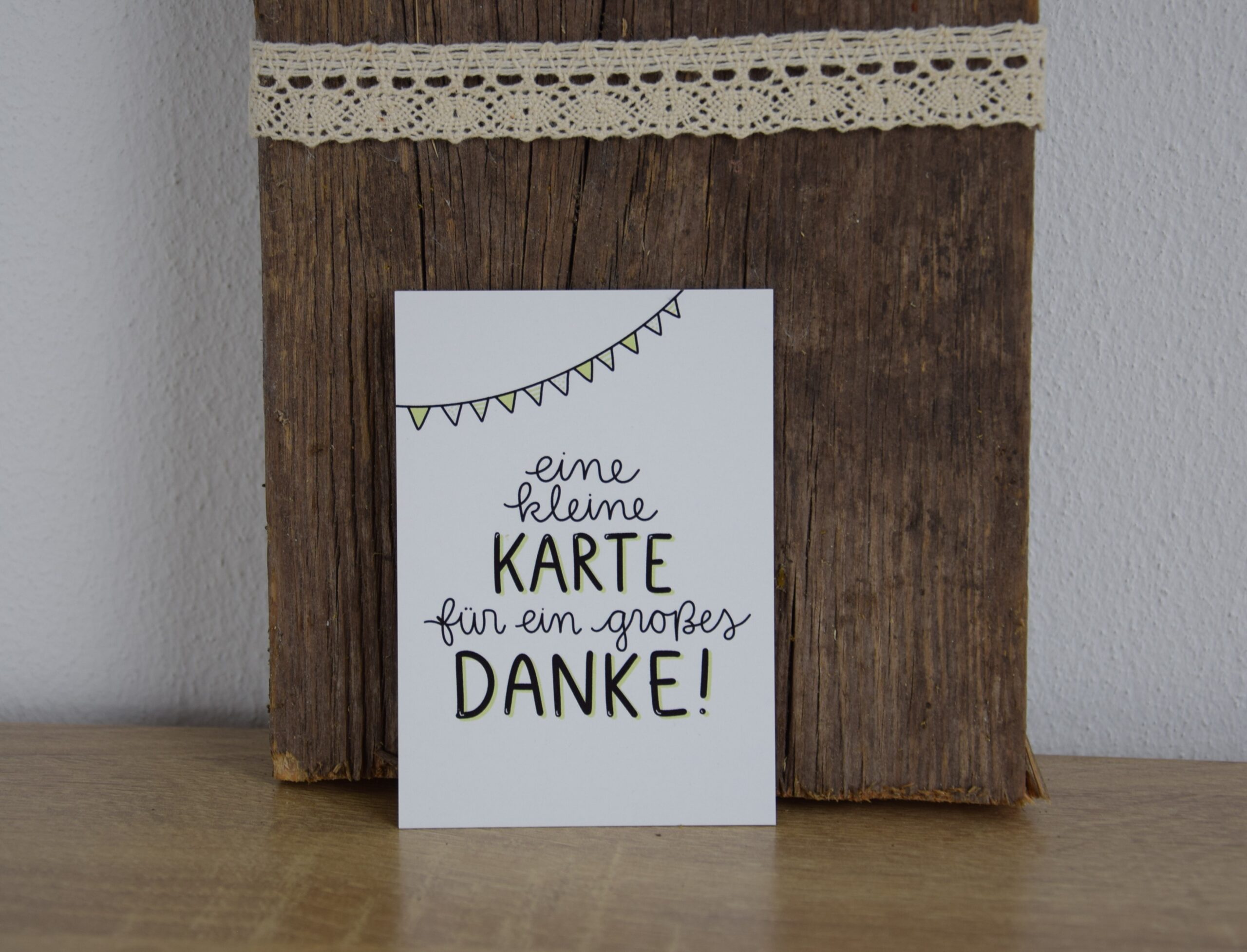 Dankeskarte mit christlichem Gruß vor Holz und Spitze.