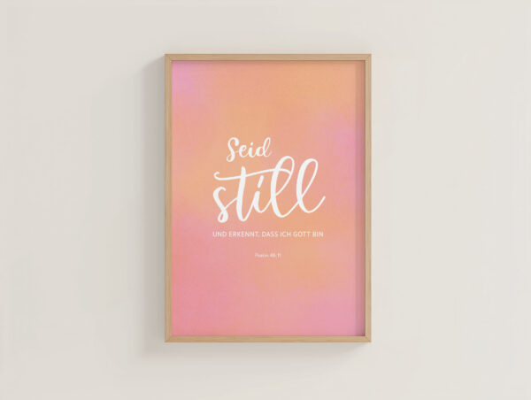 Christliches Zitat 'Seid still und erkennt, dass ich Gott bin' in rosa Rahmen.