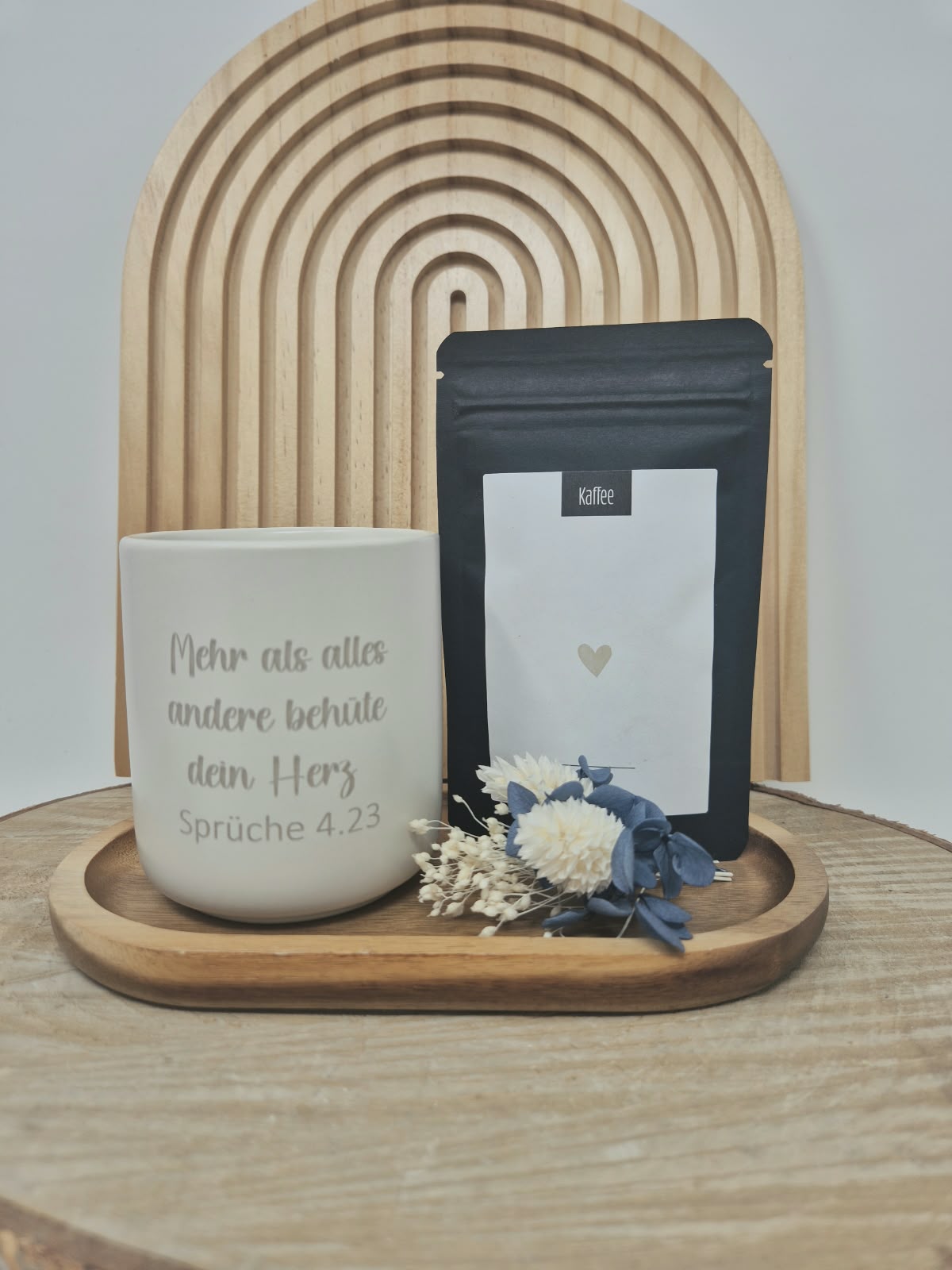 Christliche Tasse mit Bibelvers und Kaffee-Produkt auf Holztablett.