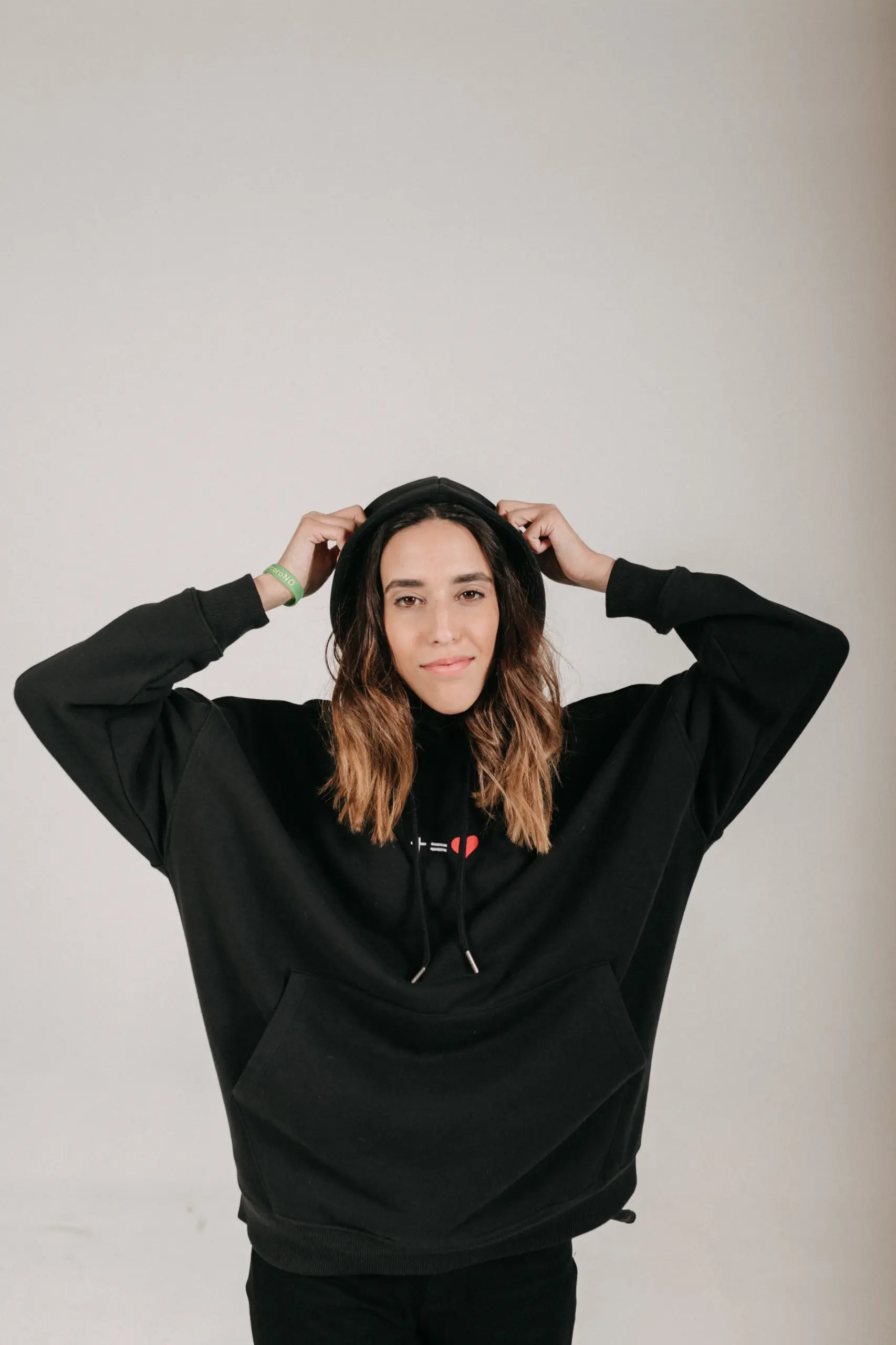 kreuzgleichliebe Hoodie Style Gratitude - unisex 16 Junge Frau trägt schwarze Kapuzenjacke mit christlichem Logo, entspannt und freundlich.