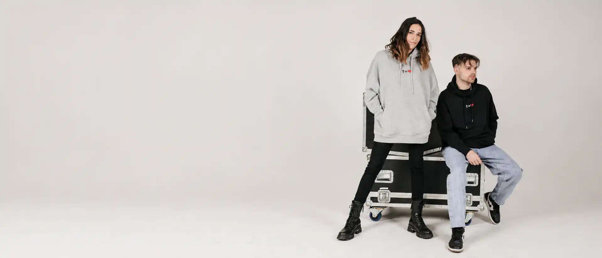 Zwei junge Menschen posieren mit Streetwear in einem Studio, christliche Marken.